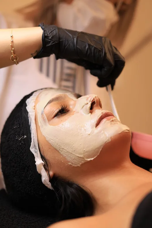 Esteticista aplica un tratamiento facial relajante a una clienta